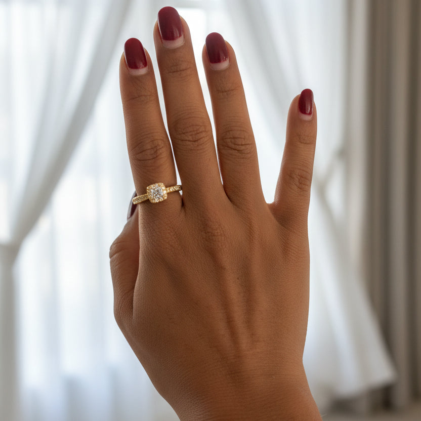 Hand wearing a gold ring with a diamond 
